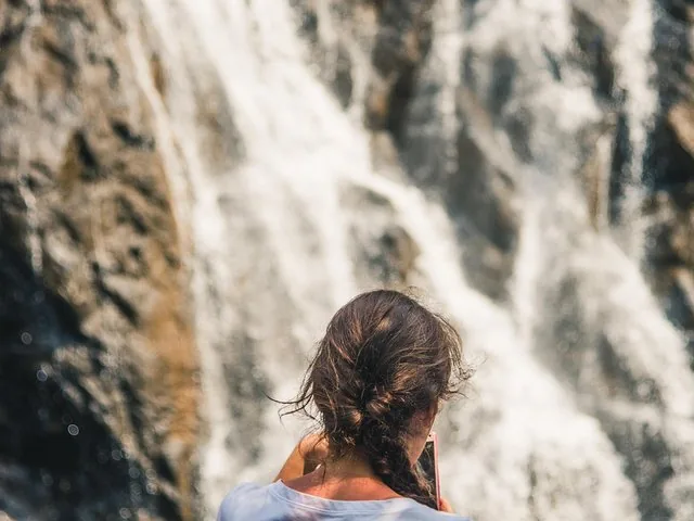 Femme photographiant une grande cascade
